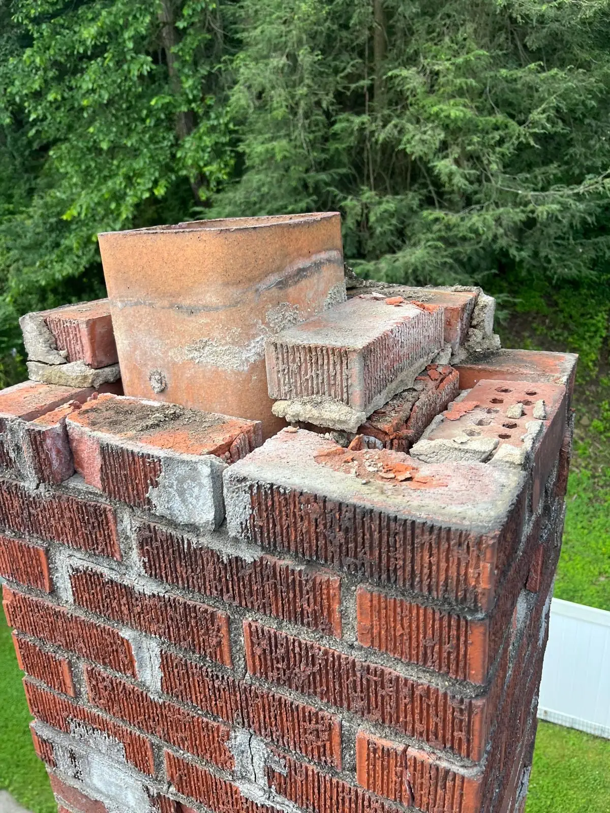 Penn Hills, PA chimney before repair: a split crown, crumbling top brick courses, and a cracked clay flue tile