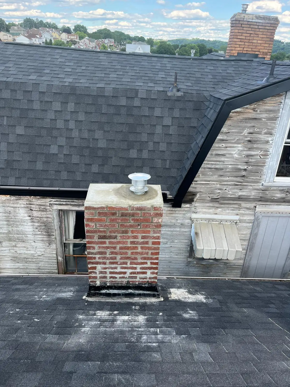Repaired chimney with a fresh concrete crown and new cap above the Allegheny Valley in Brackenridge, PA