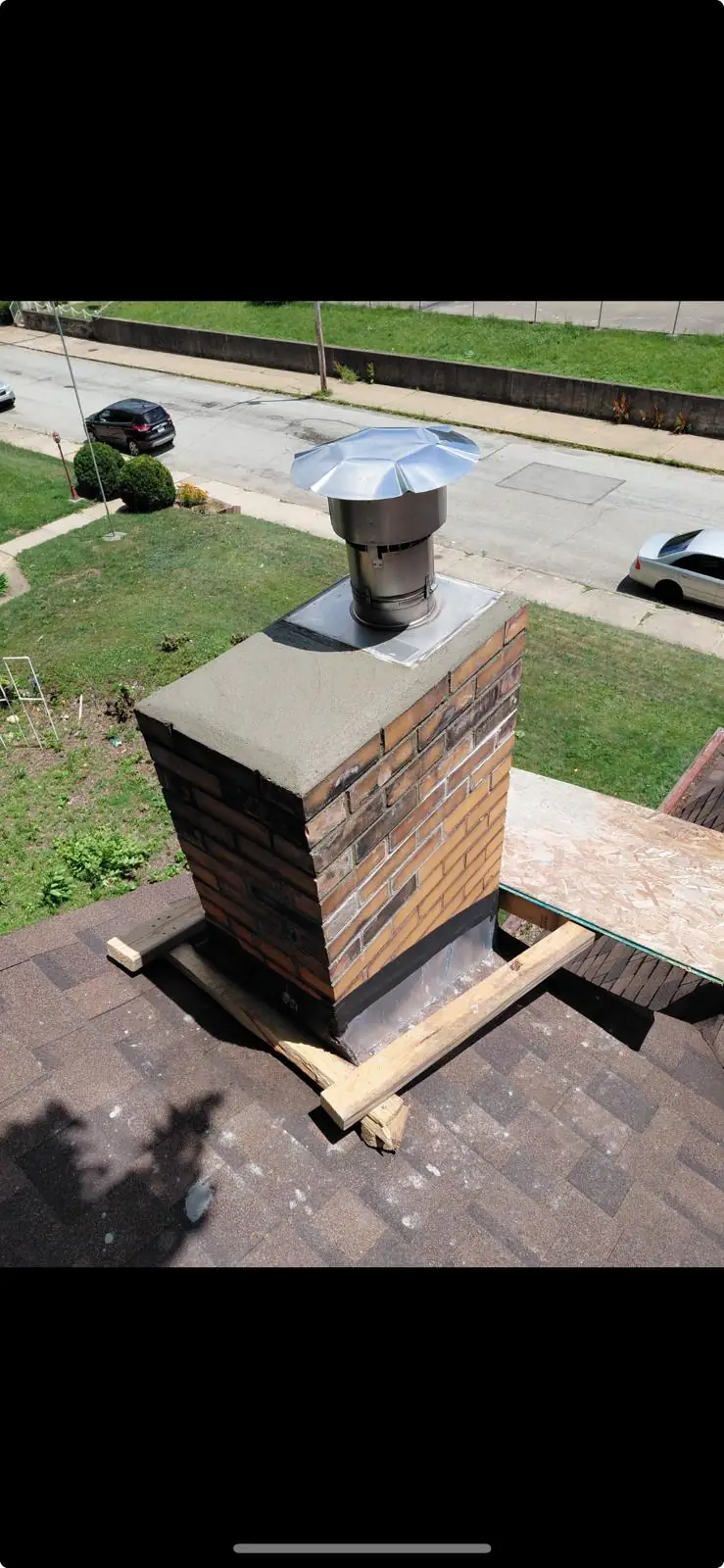 Rebuilt chimney top with a fresh concrete crown wash and new stainless steel cap in New Kensington, PA