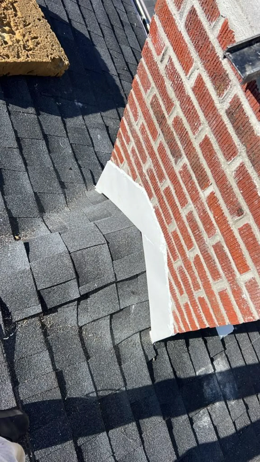 Repaired chimney flashing with new metal and a cricket installed against the high side of a Pittsburgh brick chimney