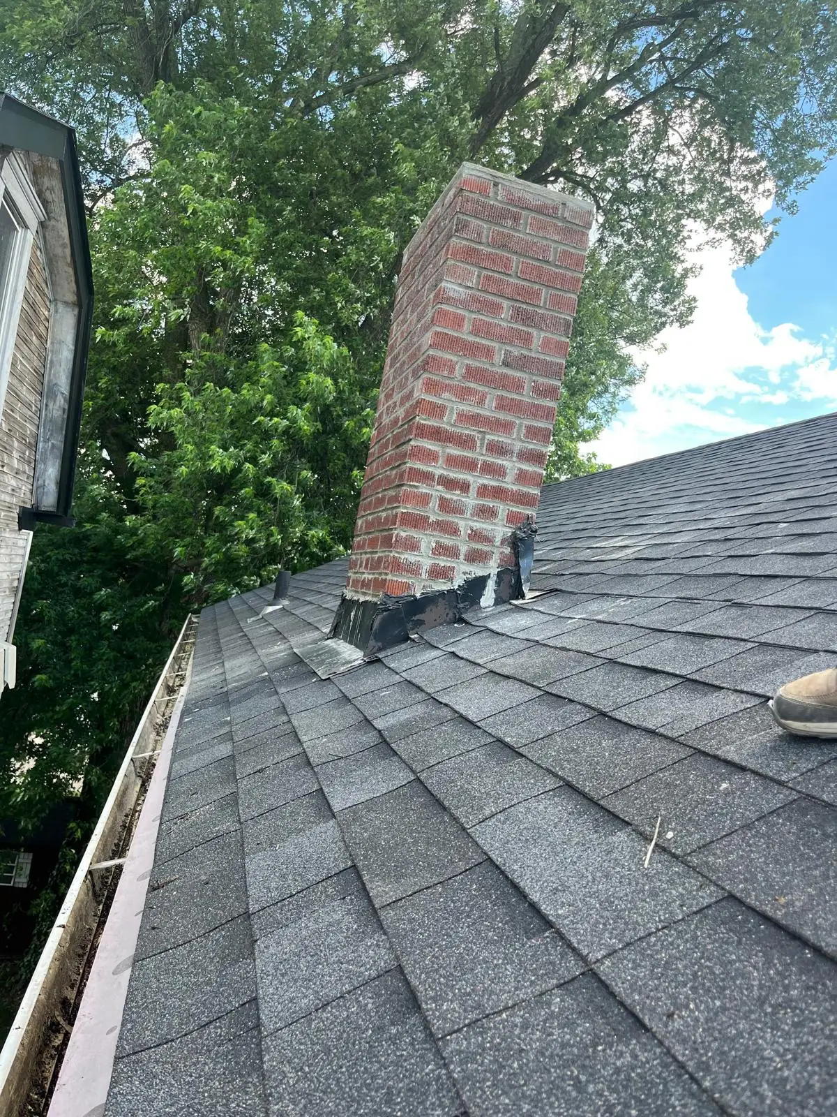 Repointed brick chimney with new sealed flashing on a Brackenridge, PA rooftop