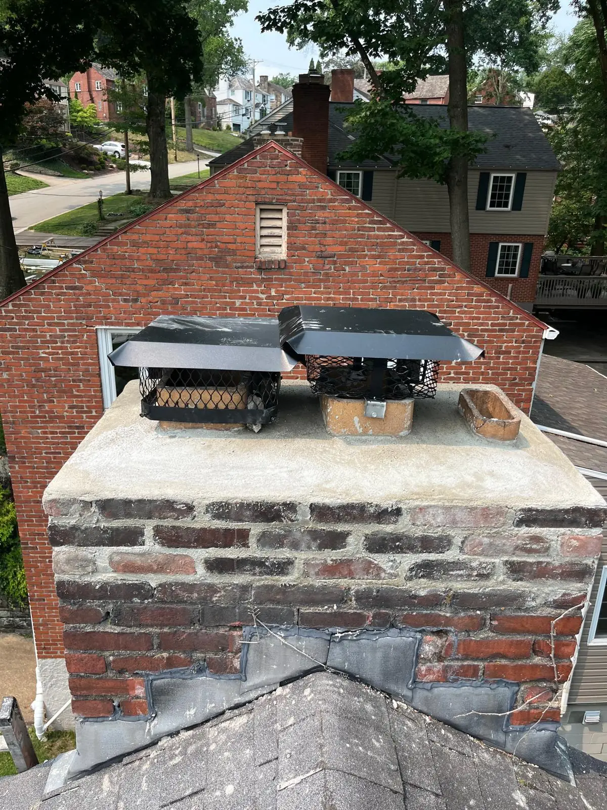 The same Mt. Lebanon, PA chimney after the top three brick courses were rebuilt, a new crown was formed, and two caps were set on the main flues