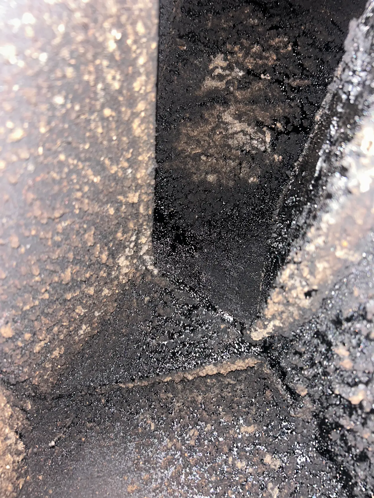Hard, shiny black glazed stage three creosote fused to the flue tile of a Pittsburgh chimney